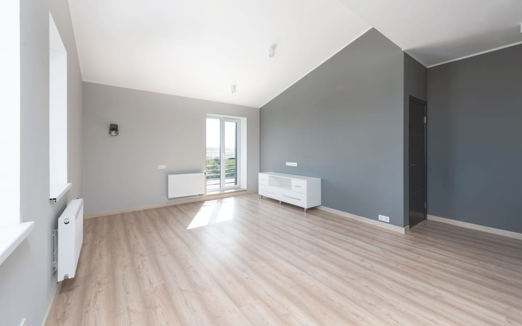 Ein heller Raum mit Dachschräge und Balkontür.